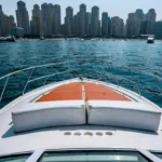 Front deck view of the 36 ft Oryx yacht cruising in Dubai Marina during a fishing trip rental