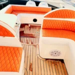 Spacious rear deck seating area with orange upholstery on the Oryx fishing yacht in Dubai